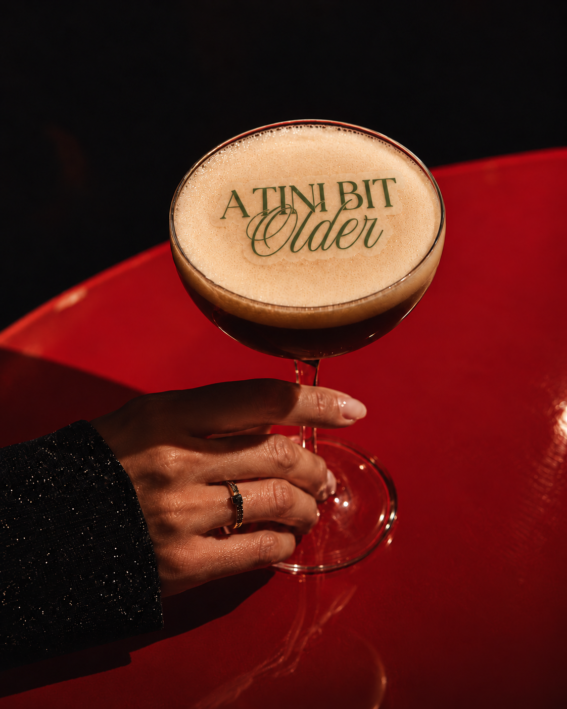 A Tini Bit Older sage green edible cocktail topper on a martini