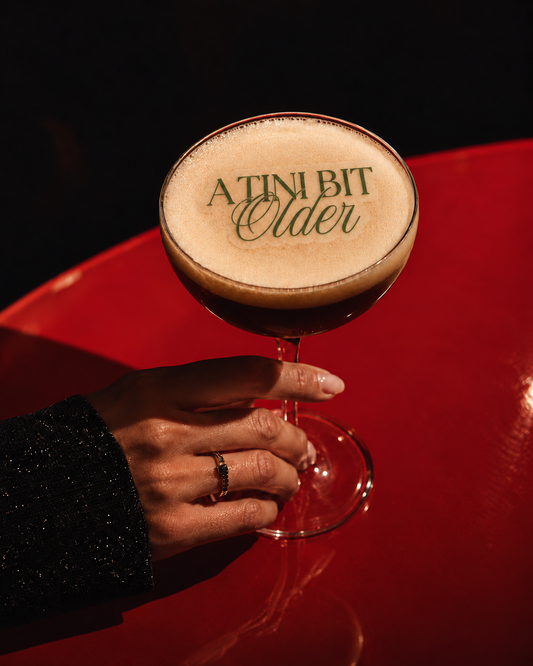 A Tini Bit Older sage green edible cocktail topper on a martini